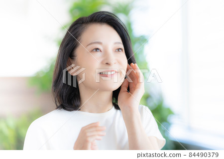 Middle-aged woman smiling with her hands on her cheeks Photo cooperation: WEEK Shibadaimon (Sun Frontier Fudousan) 84490379