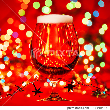 Tulip glass of beer with christmas ornament Tulip glass of beer with christmas ornament 84490484