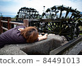Asakura City, Fukuoka Prefecture, Asakura, a village of triple water wheels, a woman taking a picture of a water wheel 84491013