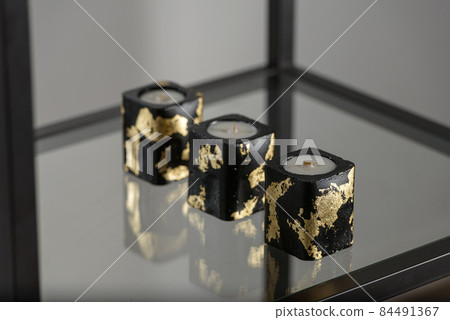 Set of stone Candle Holder with abstract smudges, cracks black concrete with golden flame. selective soft focus 84491367
