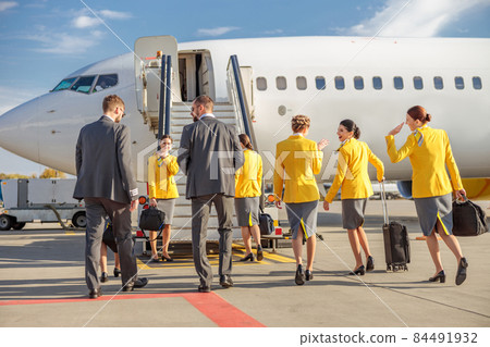 Airline workers standing near airplane at airport 84491932