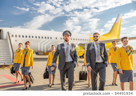 Pilots and flight attendants walking down airfield 84491934