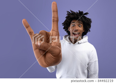 Cheerful african american guy showing hand-horns gesture 84492219