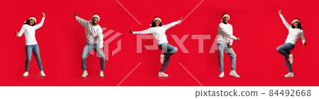 Delighted millennial black couple dancing on red, creative image, panorama 84492668