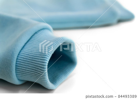 Detail of the sleeve of a blue sweatshirt with a close-up cuff.  84493389