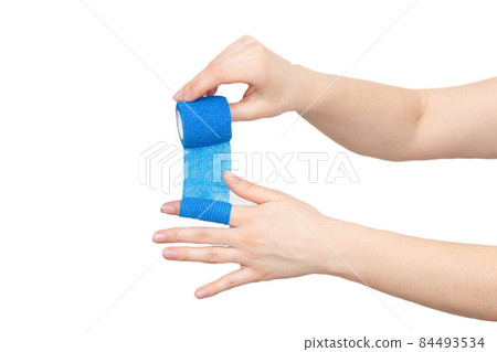 man winds an elastic bandage on his hand on a white background, isolate. The concept of fixation of the digital cleft in case of dislocation, isolated 84493534