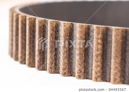 Used timing belt with small cracks. Timing belt replacement schedule. Automotive timing belt on a white background, macro 84493567