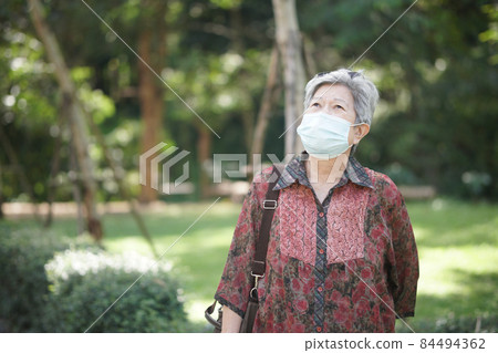 old elderly female elder woman wearing mask resting relaxing in garden. senior leisure lifestyle old elderly female elder woman wearing mask resting relaxing in garden. senior leisure lifestyle 84494362