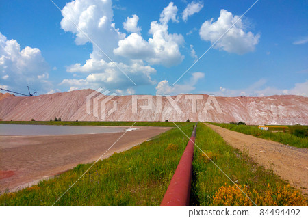 View of the production pipe against the background of spent ore for the extraction of salt and fertilizers. Minerals. 84494492