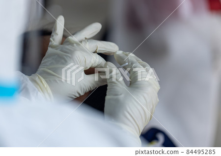 The doctor with PPE suit, Doctor is using a test coronavirus(covid-19) with the use of an ATK test kit by nasal swab. 84495285