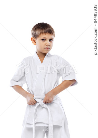 Cropped portrait of little boy in white kimono posing isolated over white background Cropped portrait of little boy in white kimono posing isolated over white background 84495938