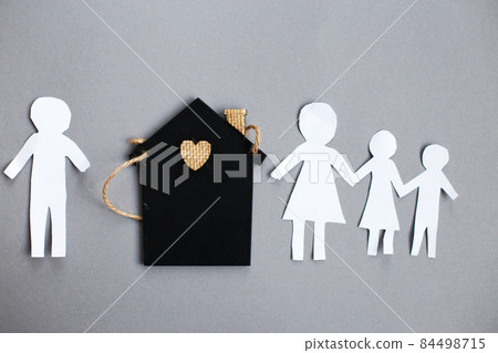 Paper chain cut family near toy house on gray background. Divorce and broken family concept Paper chain cut family near toy house on gray background. Divorce and broken family concept 84498715