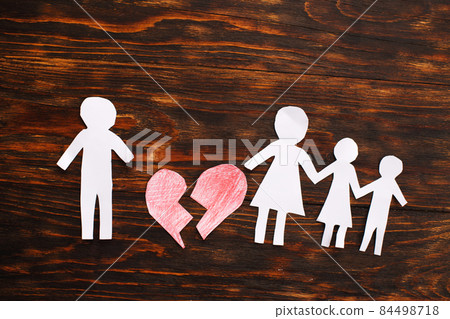 Paper chain cut family with broken heart on wooden background. Divorce and broken family concept Paper chain cut family with broken heart on wooden background. Divorce and broken family concept 84498718