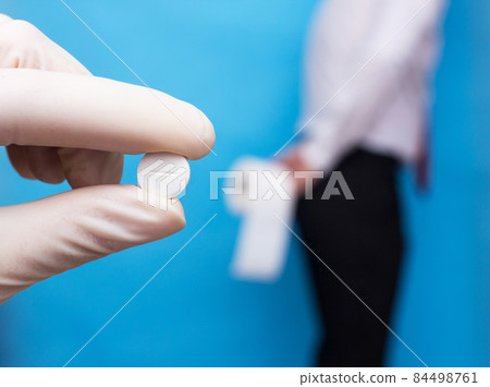 doctor holds pill medicine for diarrhea, a man stands in the background and holds toilet paper, treatment of indigestion doctor holds pill medicine for diarrhea, a man stands in the background and holds toilet paper, treatment of indigestion 84498761