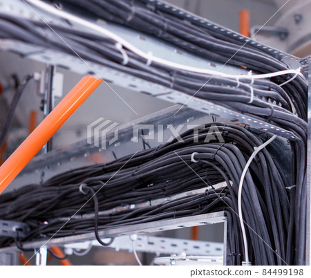 Wiring harnesses for black electrical wiring, close-up, electrical cables, industry Wiring harnesses for black electrical wiring, close-up, electrical cables, industry 84499198