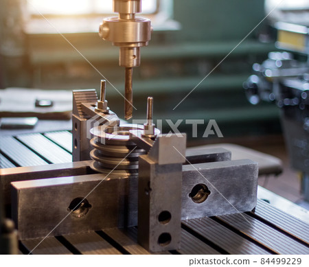 The man specialist checks the measuring tool with the size of drilling a metal pulley and inserts a drill into a drilling machine, individual entrepreneur 84499229