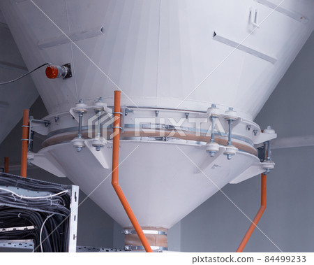 Modern plant for the production of food cereals and flour, large storage vessels for flour and cereals, close-up 84499233