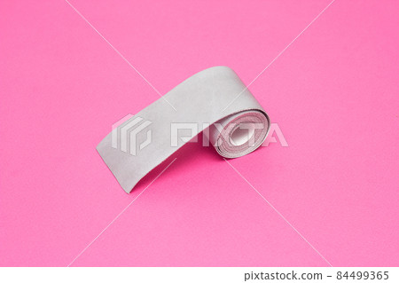 Silver tape to reflect light on a pink background, close-up, visibility on the road, safety, bandage Silver tape to reflect light on a pink background, close-up, visibility on the road, safety, bandage 84499365