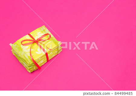 A pile of feminine sanitary pads on a pink background, close-up, copy space, periodicity, gynecology 84499485