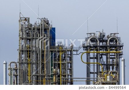 Technological installation of an oil and gas factory complex against a blue cloudless sky. 84499564