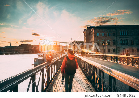 Stockholm, Sweden. Young Caucasian Woman Lady Tourist Traveler Walking On Famous Skeppsholmsbron - Skeppsholm Bridge. Popular Place, Landmark And Destination In Stockholm, Sweden 84499652
