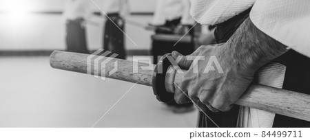 Person practicing aikido in a dojo background. 84499711