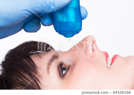 doctor buries moisturizing and vasoconstrictor eye drops to a caucasian girl, close-up, copy space doctor buries moisturizing and vasoconstrictor eye drops to a caucasian girl, close-up, copy space 84500166