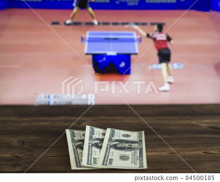 Money dollars on the background of a TV on which show table tennis, sports betting, dollars Money dollars on the background of a TV on which show table tennis, sports betting, dollars 84500185