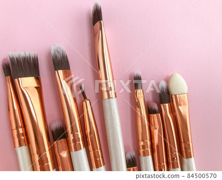 makeup brushes on a bright background. white brushes with a gold tip. natural bristles for applying texture to the face. brushes for easy application of powder 84500570