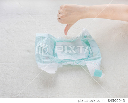 The girl checks the absorbency of the baby diaper with a napkin, and shows a gesture of a bad close-up 84500943