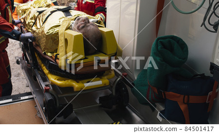 Crop paramedics loading injured survivor into vehicle 84501417