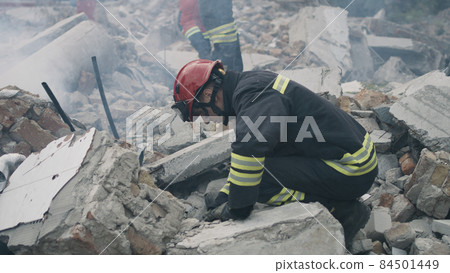Male rescuers removing concrete rubble Male rescuers removing concrete rubble 84501449