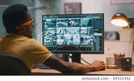 Black man watching security videos Black man watching security videos 84501492