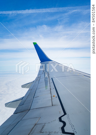 the wing of the aircraft in flight from the window of the aircraft. blue sky. the wing of the aircraft in flight from the window of the aircraft. blue sky. 84501564