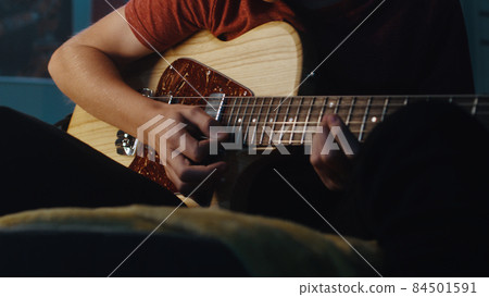 Teen musician playing guitar at night 84501591