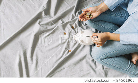 elevated view person s hand inserting coins piggybank. High quality photo 84501905