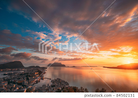 Alesund, Norway. Amazing Natural Bright Sunset Dramatic Sky In Warm Colours Above Alesund Islands. Famous Norwegian Landmark And Popular Destination. Top View Alesund, Norway. Amazing Natural Bright Sunset Dramatic Sky In Warm Colours Above Alesund Islands. Famous Norwegian Landmark And Popular Destination. Top View 84502131