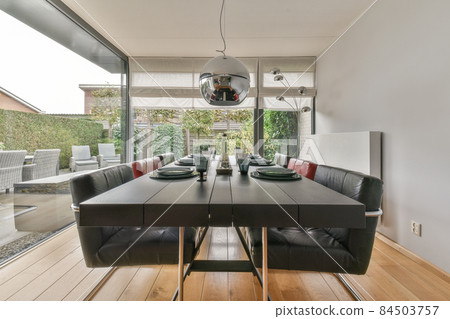 Interior of light room with stylish dining and lounge areas in modern house at daytime Interior of light room with stylish dining and lounge areas in modern house at daytime 84503757