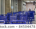 Empty blue plastic chairs in a public place 84504478
