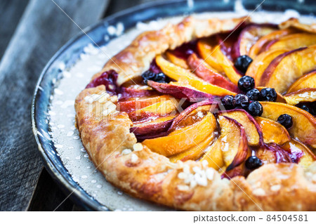 Rustic open pie (galette) with peach and berry Rustic open pie (galette) with peach and berry 84504581