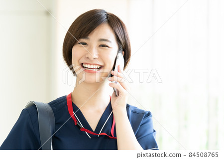 Medical worker woman talking on a smartphone 84508765