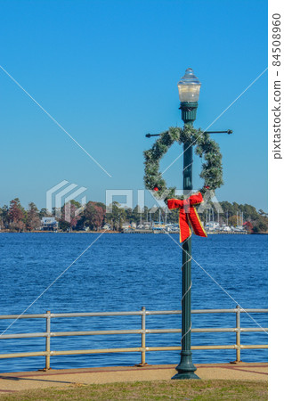 Christmas Wreath hanging from a light post in Union Point Park, New Bern, Craven County, North Carolina 84508960