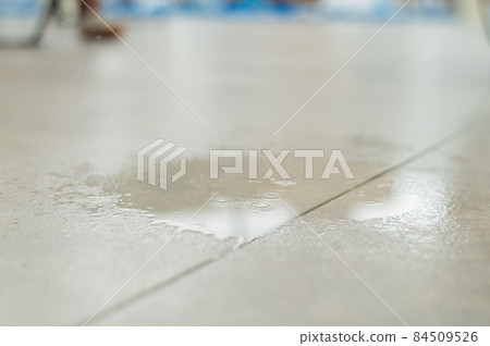Water drips onto the tiled floor. 84509526