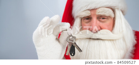 Santa Claus holds keys on a white background. New home gift for christmas. 84509527