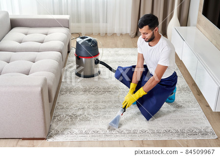 Close-up of housekeeper holding modern washing vacuum cleaner and