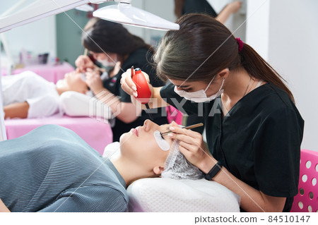 Process of eyelash extensions in the beauty studio Process of eyelash extensions in the beauty studio 84510147