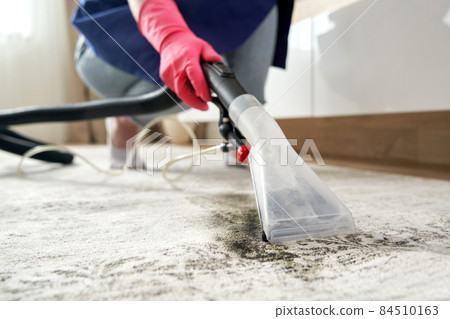 Human Cleaning Carpet In The Living Room Using Vacuum Cleaner At Home Human Cleaning Carpet In The Living Room Using Vacuum Cleaner At Home 84510163