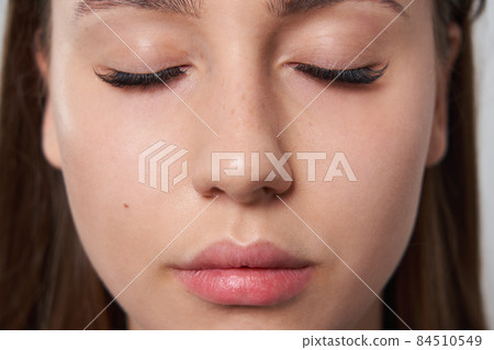 Beautiful girl with extended eyelashes and eyes closed 84510549
