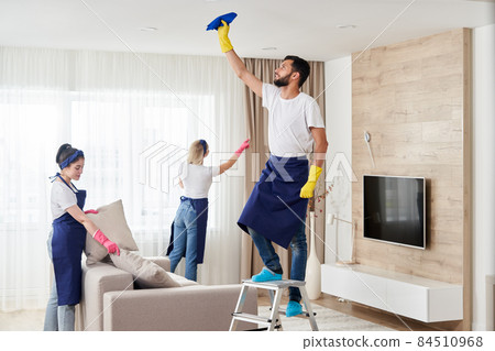 Professional cleaning service team cleans living room in modern apartment Professional cleaning service team cleans living room in modern apartment 84510968