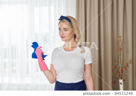 Young woman holding cleaning rag for dusting. Cleaning service or housewife concept 84511249